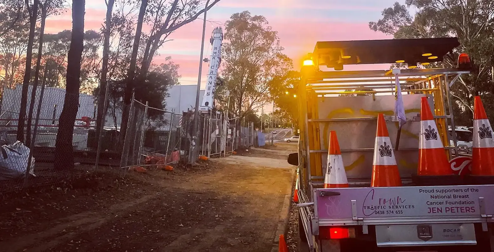 A Crown Traffic Services ute with its arrow board raised at sunrise